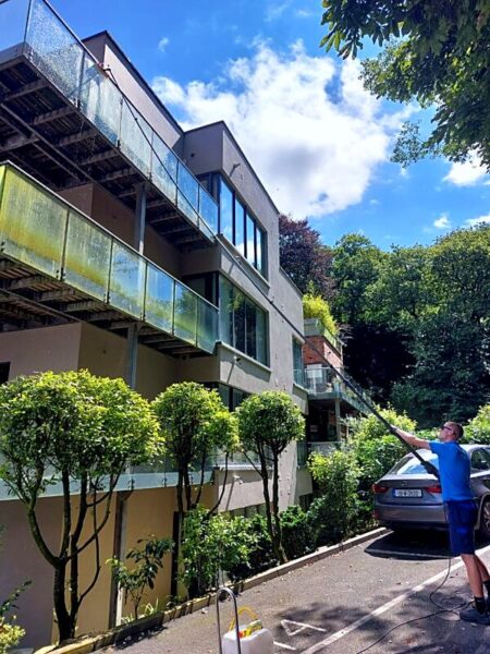 Cleaning apartment balcony glass with a water-fed pole