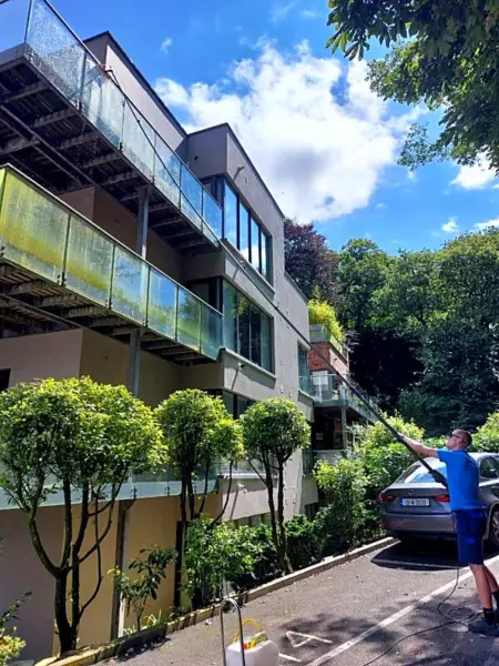 Cleaning apartment balcony glass with a water-fed pole