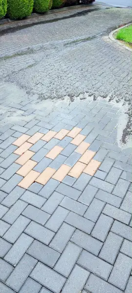 Block paving driveway half cleaned, showing the difference