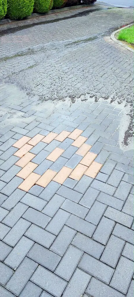 Block paving driveway half cleaned, showing the difference