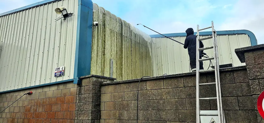 Washing algae off warehouse cladding