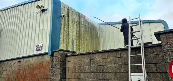 Washing algae off warehouse cladding