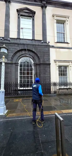 Terry, iShine’s owner/operator, cleaning the windows of a Georgian building with a water-fed pole