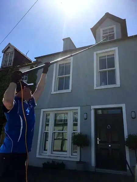 Cleaning the upstairs windows of a period house with a water-fed pole