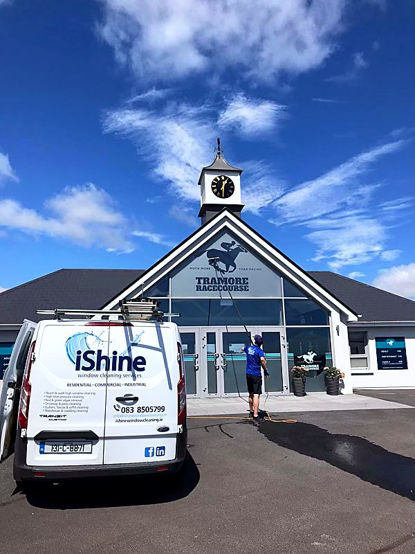 iShine van parked outside a racecourse building while Terry, iShine’s owner/operator, cleans the glazing