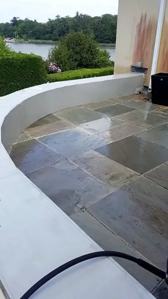 Clean slate patio beside a curved wall after pressure washing