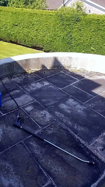 Dark, dirty slate patio before pressure washing
