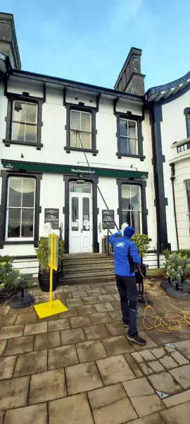 Terry, iShine’s owner/operator, cleaning the windows of a period building in town