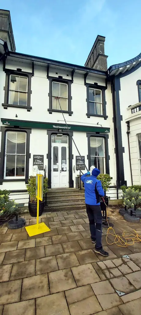 Terry, iShine’s owner/operator, cleaning the windows of a period building in town