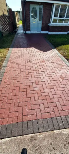 A clean red block paving path to a front door