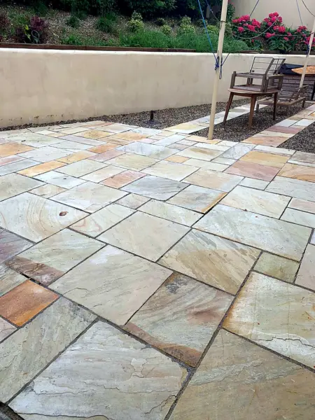 A clean sandstone patio with garden furniture
