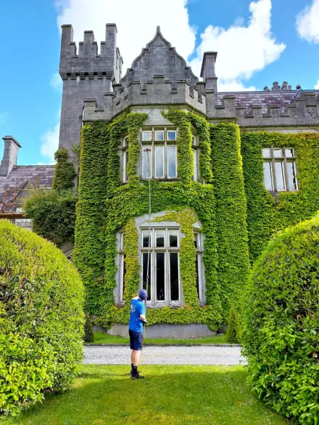 Terry, iShine’s owner/operator, cleaning the windows of an ivy-covered period building