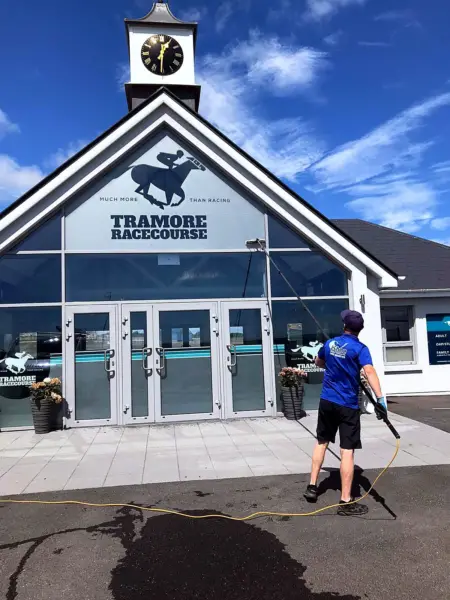 Terry, iShine’s owner/operator, cleaning the glass entrance of Tramore Racecourse