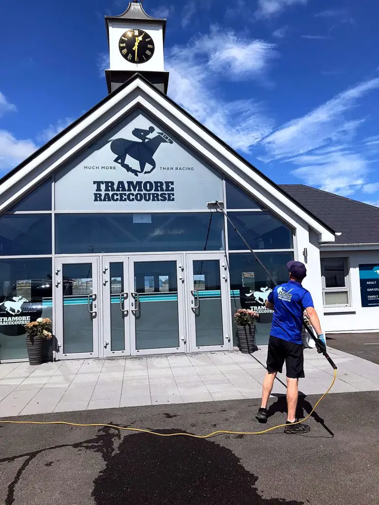 Terry, iShine’s owner/operator, cleaning the glass entrance of Tramore Racecourse