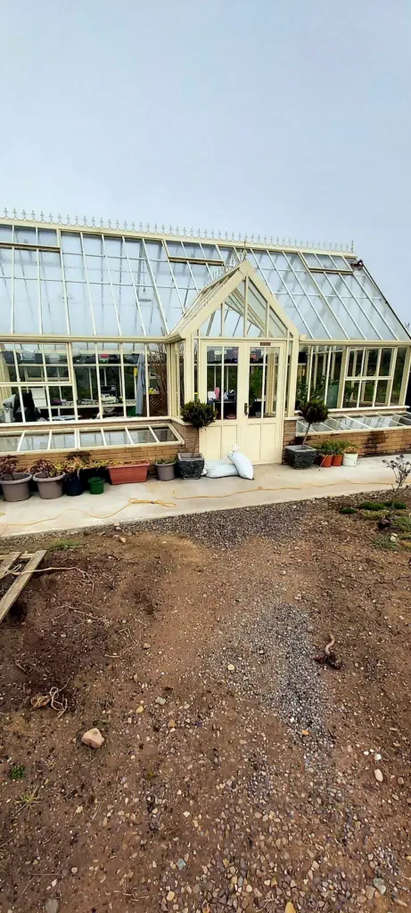 A Victorian-style glasshouse in a garden