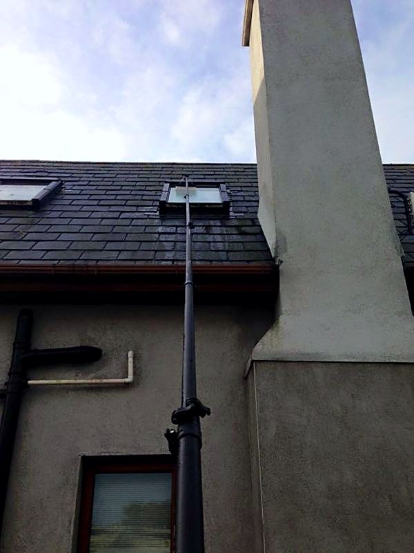 Water-fed pole reaching up to a Velux roof window